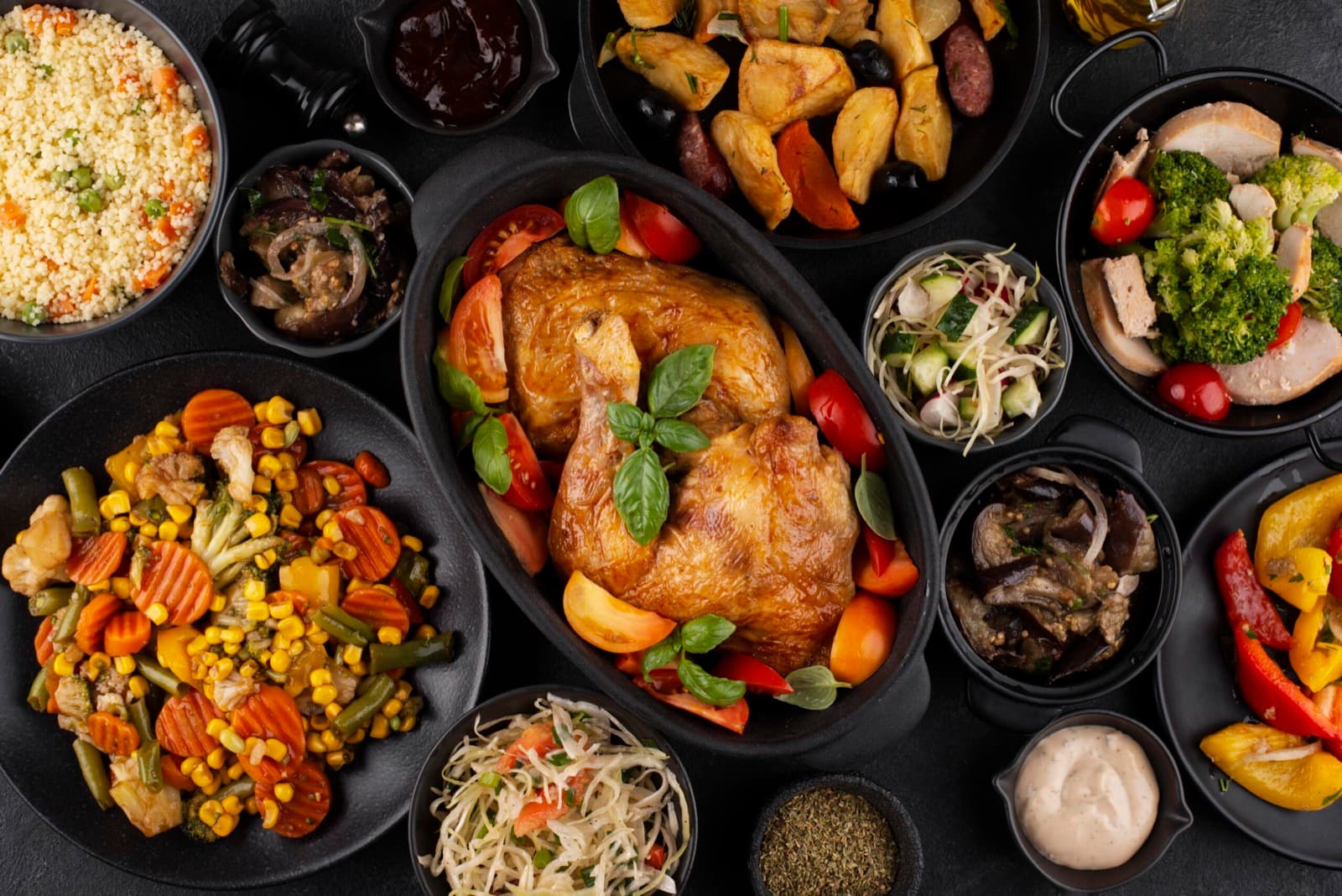Une table généreuse : poulet rôti, légumes, salades et sauces
